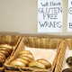 Bagels in baskets with signs reading "we have gluten free wraps and bagels"